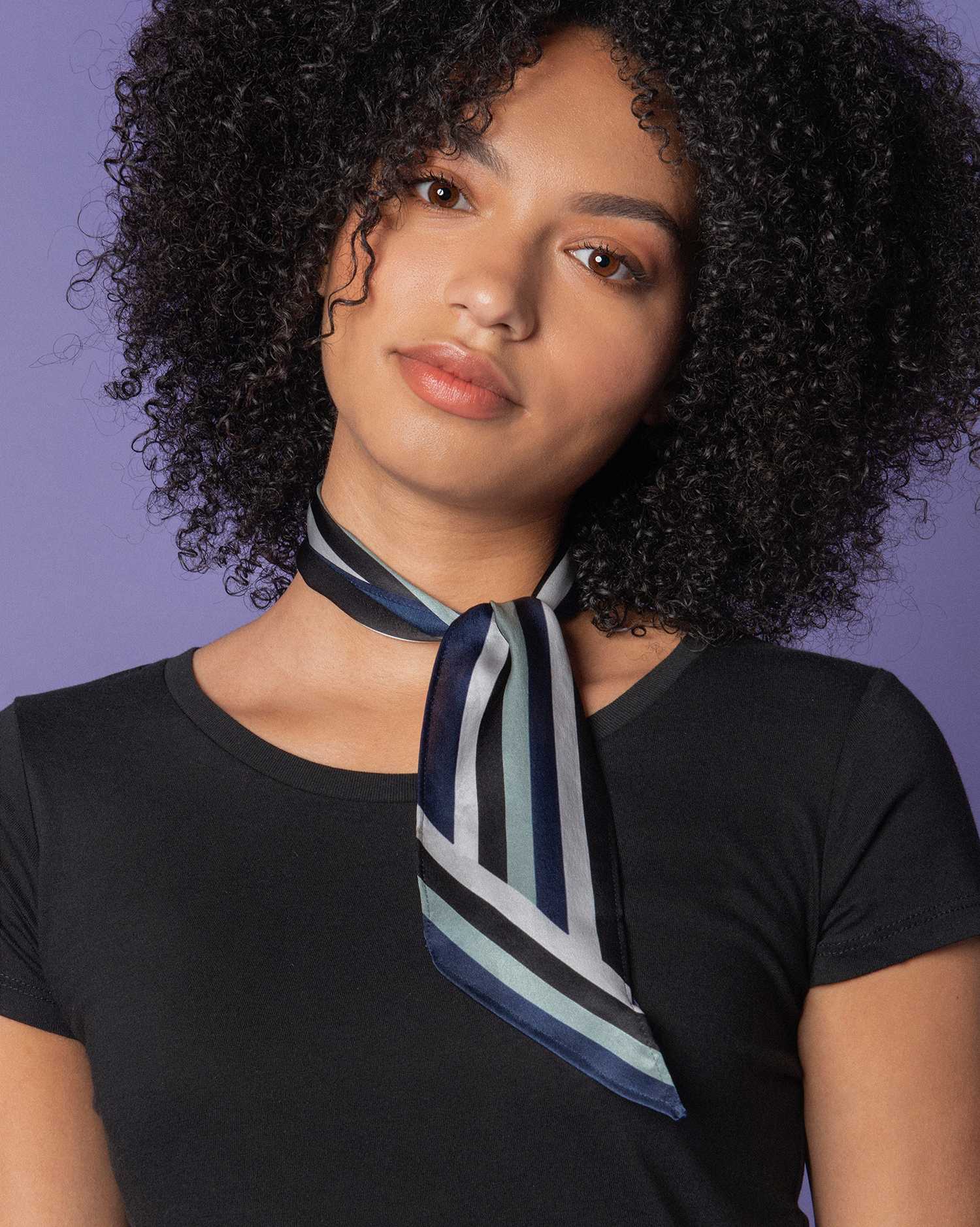 A girl wearing a blue striped printed silk neck scarf henley 